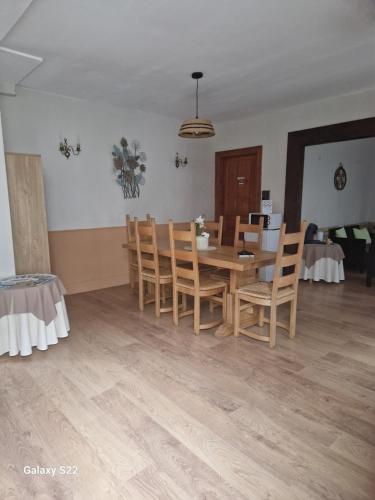 une salle à manger avec une table et des chaises en bois dans l'établissement Les chambres de l'auberge, à Watten