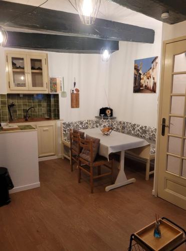 une cuisine avec une table et des chaises dans une pièce dans l'établissement les 4 saisons, à Camarès