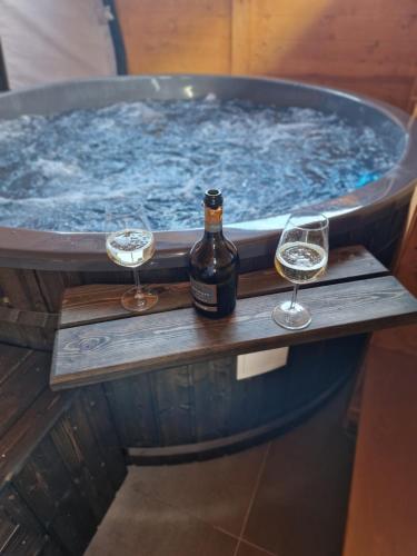 a bottle of wine and two glasses in a hot tub at Cabana Tesa Borșa MM in Statiunea Borsa