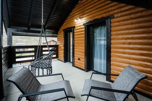a porch with two chairs and a porch swing at Cabana Tesa Borșa MM in Statiunea Borsa