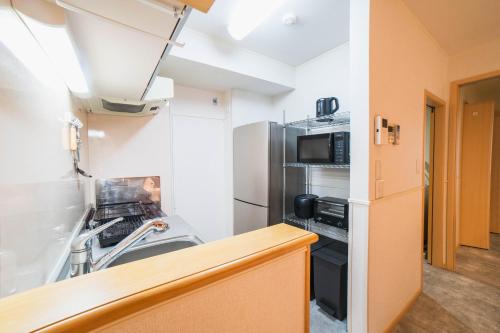a kitchen with a stove and a refrigerator at New open! Dream ASUNARO 5 minuites from Shinsaibashi in Osaka