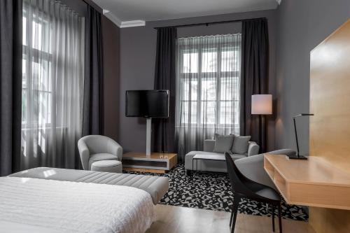 a hotel room with a bed and a desk at Le Méridien Vienna in Vienna