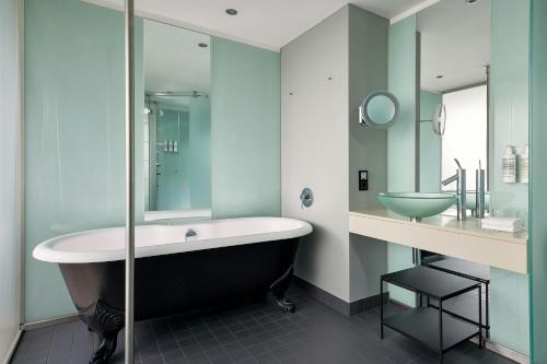 a bathroom with a bath tub and a sink at Le Méridien Vienna in Vienna