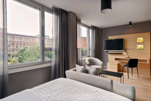a hotel room with a bed and a tv and window at Le Méridien Vienna in Vienna