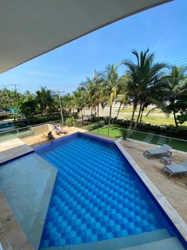 卡塔赫纳Apartment with direct access to the Sea in CTG的背景为棕榈树的游泳池