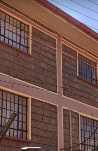 a brick building with windows on the side of it at Cozy Homes in Thika