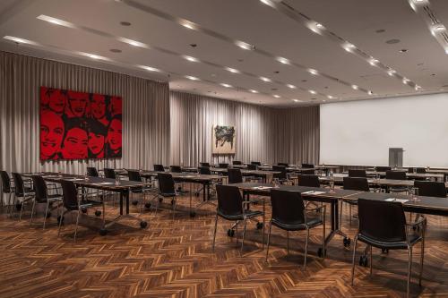 a conference room with tables and chairs and a screen at Le Méridien Vienna in Vienna
