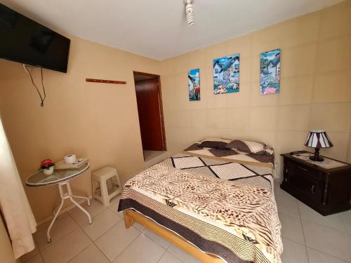 a bedroom with a bed and a table and a tv at Casablanca in Pisco