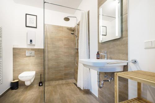 a bathroom with a toilet and a sink and a shower at Boardinghaus Grünefeld I W7 I modernes Apartment I P I Smart I Office in Mettingen