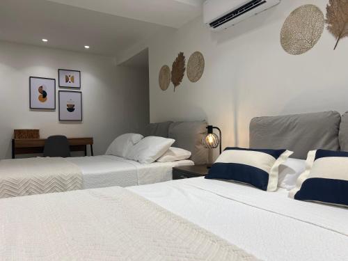 two beds in a room with white and blue at Apartment with direct access to the Sea in CTG in Cartagena de Indias
