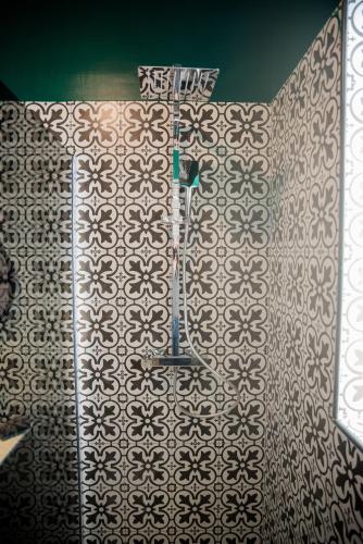 La salle de bains est pourvue d'un mur en carrelage et d'une douche. dans l'établissement Mezza'Cosy, apt avec parking à 2 pas de la Cité, à Carcassonne