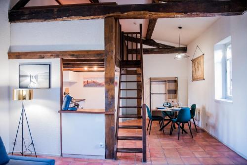 Cette chambre comprend une mezzanine, une table et des chaises. dans l'établissement Mezza'Cosy, apt avec parking à 2 pas de la Cité, à Carcassonne