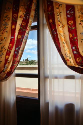 a window with curtains looking out at a view at Hostería de Guara in Bierge