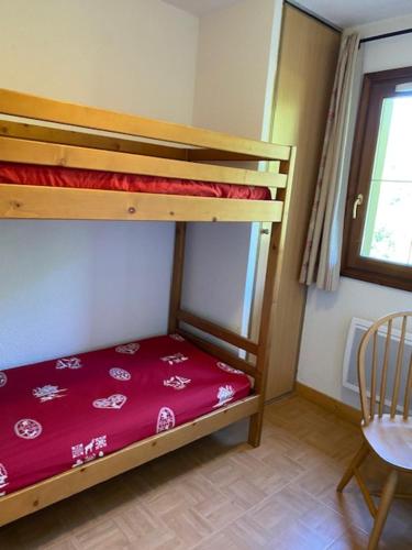 une chambre avec deux lits superposés et une table dans l'établissement Appt 4 pers terrasse, piscine au pied des pistes FLUMET, à Flumet