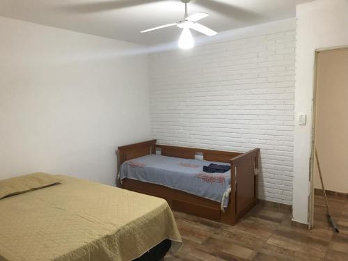 a bedroom with a bed and a ceiling fan at Chácara em São Pedro com piscina e churrasqueira in São Pedro