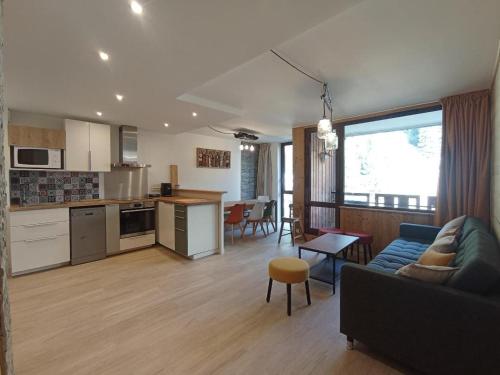 un salon et une cuisine avec un canapé et une table dans l'établissement Cozy appartement plagne Bellecote, à La Plagne Tarentaise