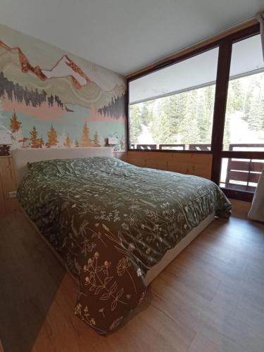 une chambre avec un lit et une grande fenêtre dans l'établissement Cozy appartement plagne Bellecote, à La Plagne Tarentaise