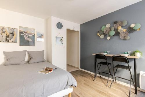 une chambre avec un lit et une table avec des chaises dans l'établissement Studio Lumière in Lyon, à Lyon
