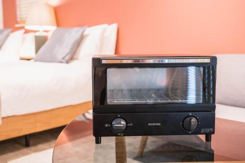 a toaster oven sitting on a table in a room at New open! Dream ASUNARO 5 minuites from Shinsaibashi in Osaka