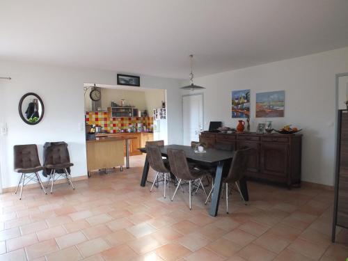 une salle à manger avec une table et des chaises dans l'établissement Maison Familiale à St-Brevin - Confort & Sérénité, à Saint-Brévin-les-Pins