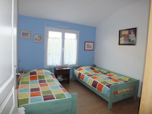 deux lits dans une chambre aux murs bleus dans l'établissement Maison Familiale à St-Brevin - Confort & Sérénité, à Saint-Brévin-les-Pins