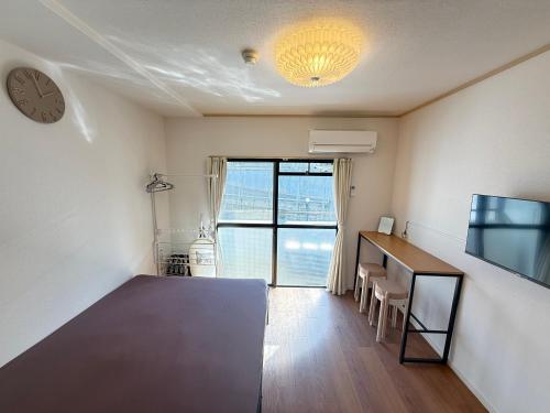 a room with a desk and a clock on the wall at Serene Highness in Dazaifu