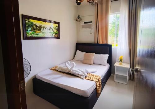a small bedroom with a bed with two towels on it at Spacious 2BR Staycation with FREE Gym, Parking & Pool - B2 1Nambulite in Puerto Princesa City