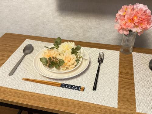 a table with a plate with flowers on it at Serene Highness in Dazaifu