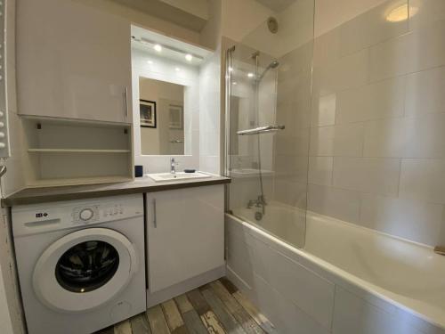 une salle de bain avec un lave-linge et une baignoire dans l'établissement Appartement calme avec balcon, parking, près du port de Perros-Guirec - FR-1-368-412, à Perros-Guirec