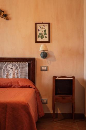 a bedroom with a bed and a nightstand with a television at Agriturismo Casal Gheriglio in Lucignano