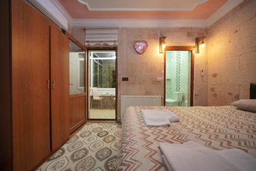 a bedroom with a bed and a door to a bathroom at Cappadocia Silkroad House in Avcılar