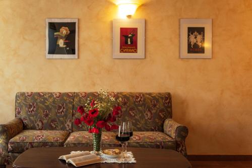 a living room with a couch and a table with wine glasses at Agriturismo Casal Gheriglio in Lucignano