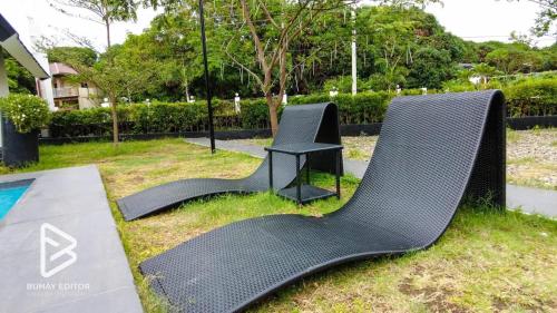 a chair and a table sitting on the grass at Las Villas De La Serenidad in Calatagan
