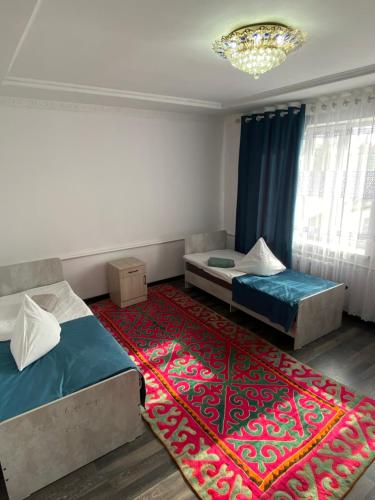 1 dormitorio con 2 camas y alfombra roja en Guest house Lux, en Kochkorka