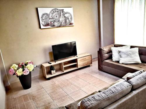 a living room with a couch and a flat screen tv at rentapartBDSH in Tarapoto