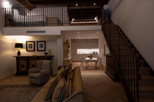 a living room with a staircase and a table at Palazzo Doni by Florence Art Apartments in Florence