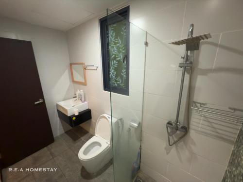 a bathroom with a toilet and a glass shower stall at Vivacity Jazz Suites Kuching by REA Homestay in Kuching