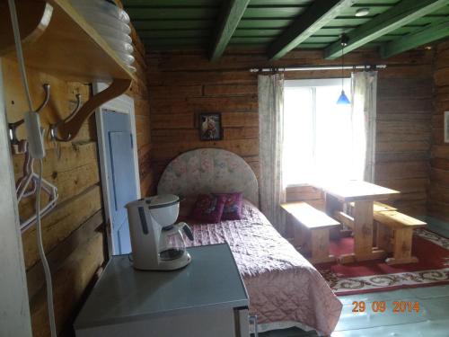 a bedroom with a bed in a log cabin at Vuohensaari Camping Ahtela's cottage in Salo