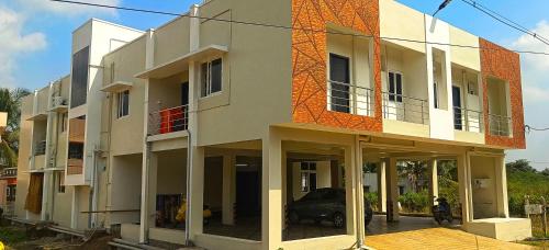 a building with a car parked in front of it at Shivalaya's 2BHK Service Apartment Near Adiyogi & Siruvani in Alāndurai