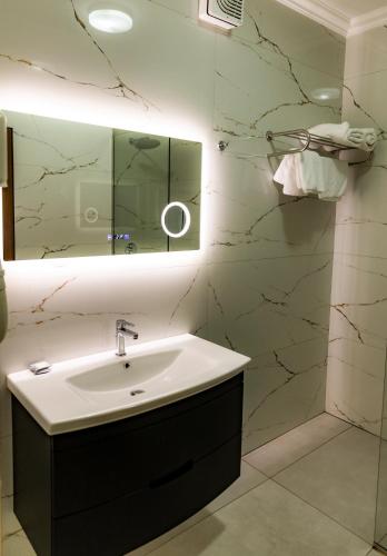 a bathroom with a sink and a mirror at Hotel Univers Laç in Fushë-Milot