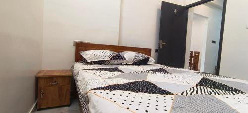 a bedroom with a bed with a black and white comforter at Shivalaya's 2BHK Service Apartment Near Adiyogi & Siruvani in Alāndurai