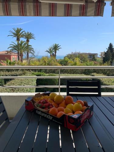 - une boîte de fruits sur une table sur un balcon dans l'établissement Charmant 3 pièces vue mer, à Antibes