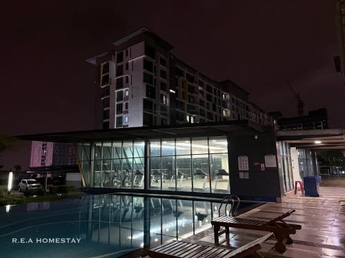 a building with a swimming pool at night at Vivacity Jazz Suites Kuching by REA Homestay in Kuching