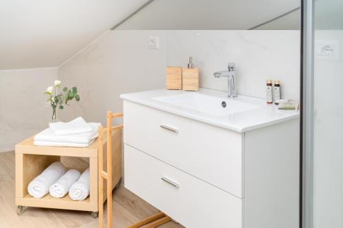 łazienka z umywalką i półką z ręcznikami w obiekcie Otium Rooms / Camere e Appartamenti w mieście Morrovalle