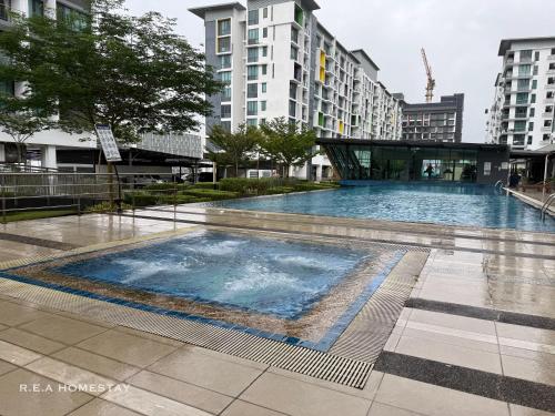 a large swimming pool in a city with tall buildings at Vivacity Jazz Suites Kuching by REA Homestay in Kuching
