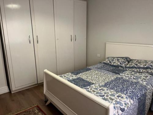 a bedroom with a bed and some white cabinets at Cosy & central 2 bedroom apartment in 6th Of October