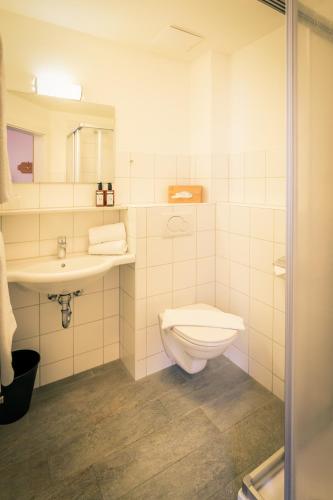 a bathroom with a toilet and a sink at Posthotel Lechtal, Arlberg in Holzgau