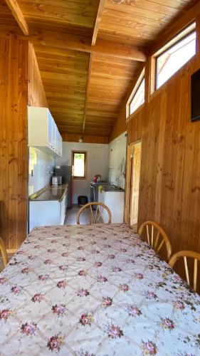 a dining room with a table and a kitchen at Parcela Patty in Pucura
