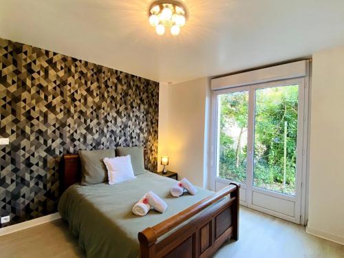 - une chambre avec un lit doté d'oreillers roses et d'une fenêtre dans l'établissement Spacieux appartement terrasse au coeur de la ville, à Quimperlé