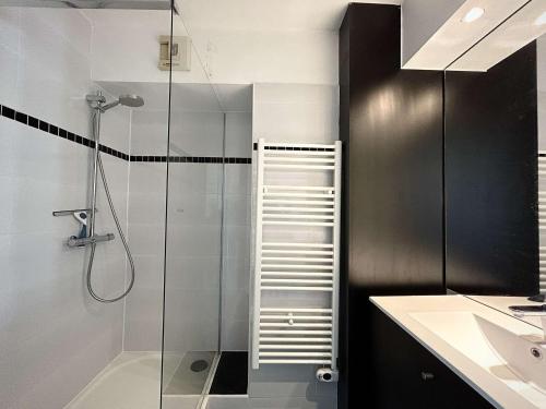 une salle de bain avec une douche avec une porte vitrée dans l'établissement Appartement avec mezzanine, piscine et parking - proche plage et clubs sportifs à La Baule - FR-1-245-43, à Guérande